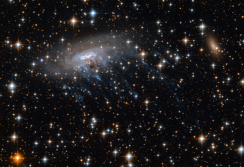 Illustration for article titled Haunting new Hubble image shows a galaxy being ripped to shreds